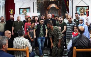 Pe. Habemba com famílias cristãs que terão suas casas em Homs reconstruídas.