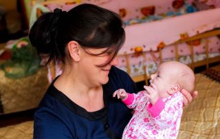 Mãe e seu bebê em centro de acolhida para mulheres na Rússia