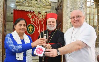 Senhora recebe oliveira que marca início da reconstrução dos lares de Nínive