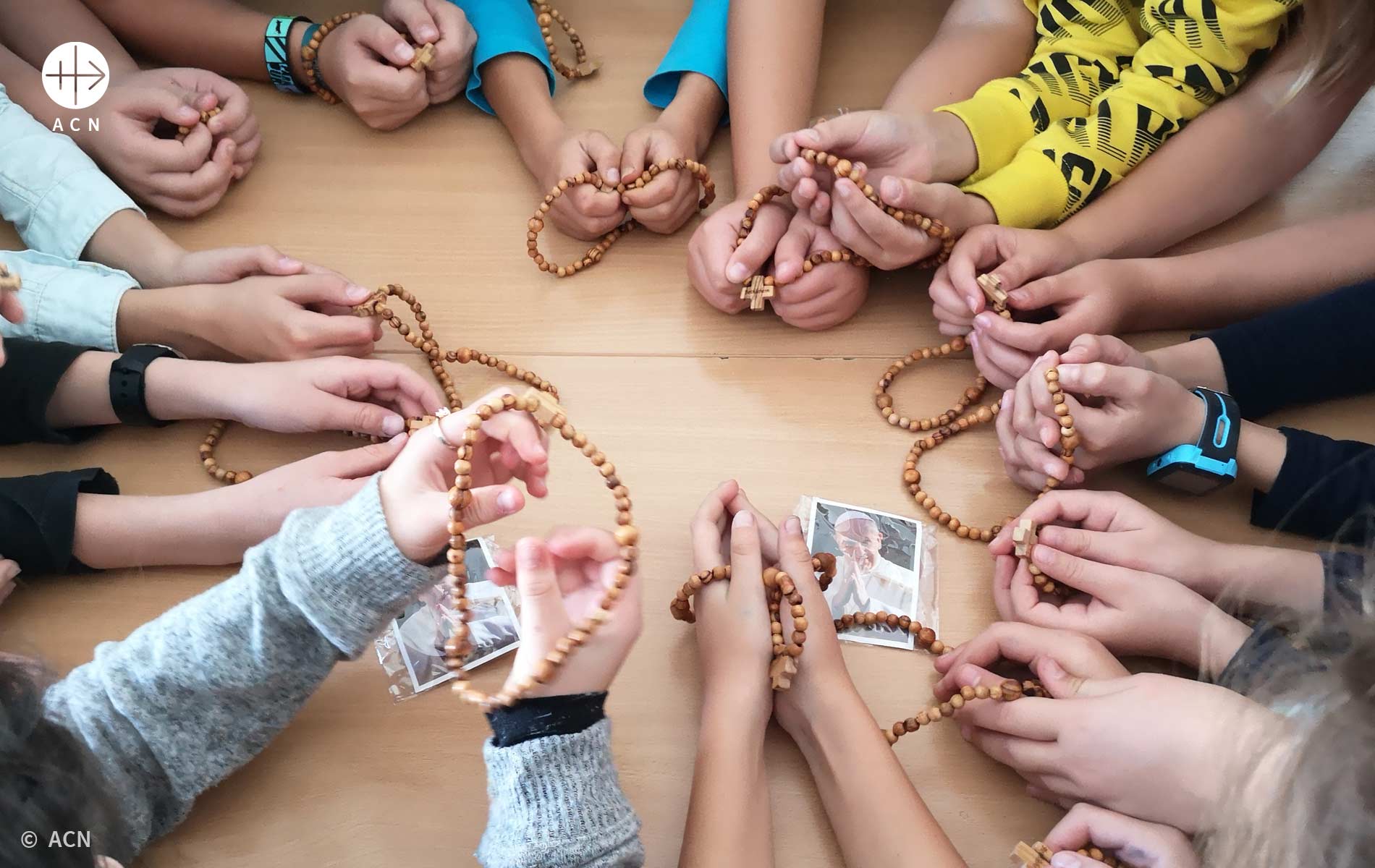 Foto de criançs rezando o terço