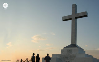 foto de grupo de pessoas rezando diante da ciz