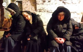 Freiras em abrigo subterraneop rezando o terço